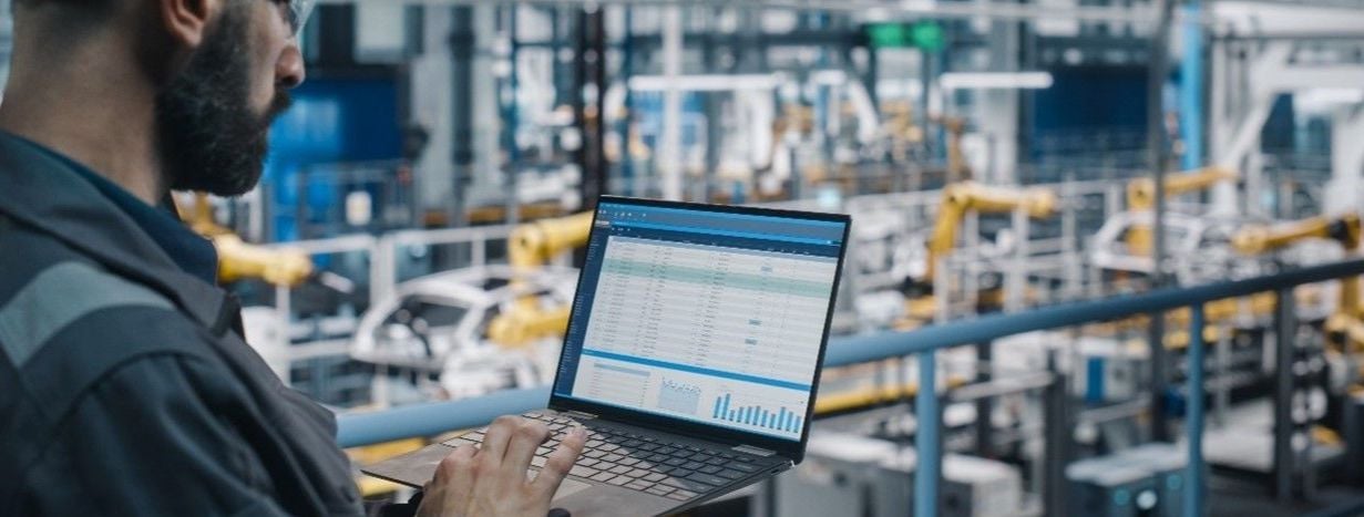 Man working on operations optimization with his laptop in his hands