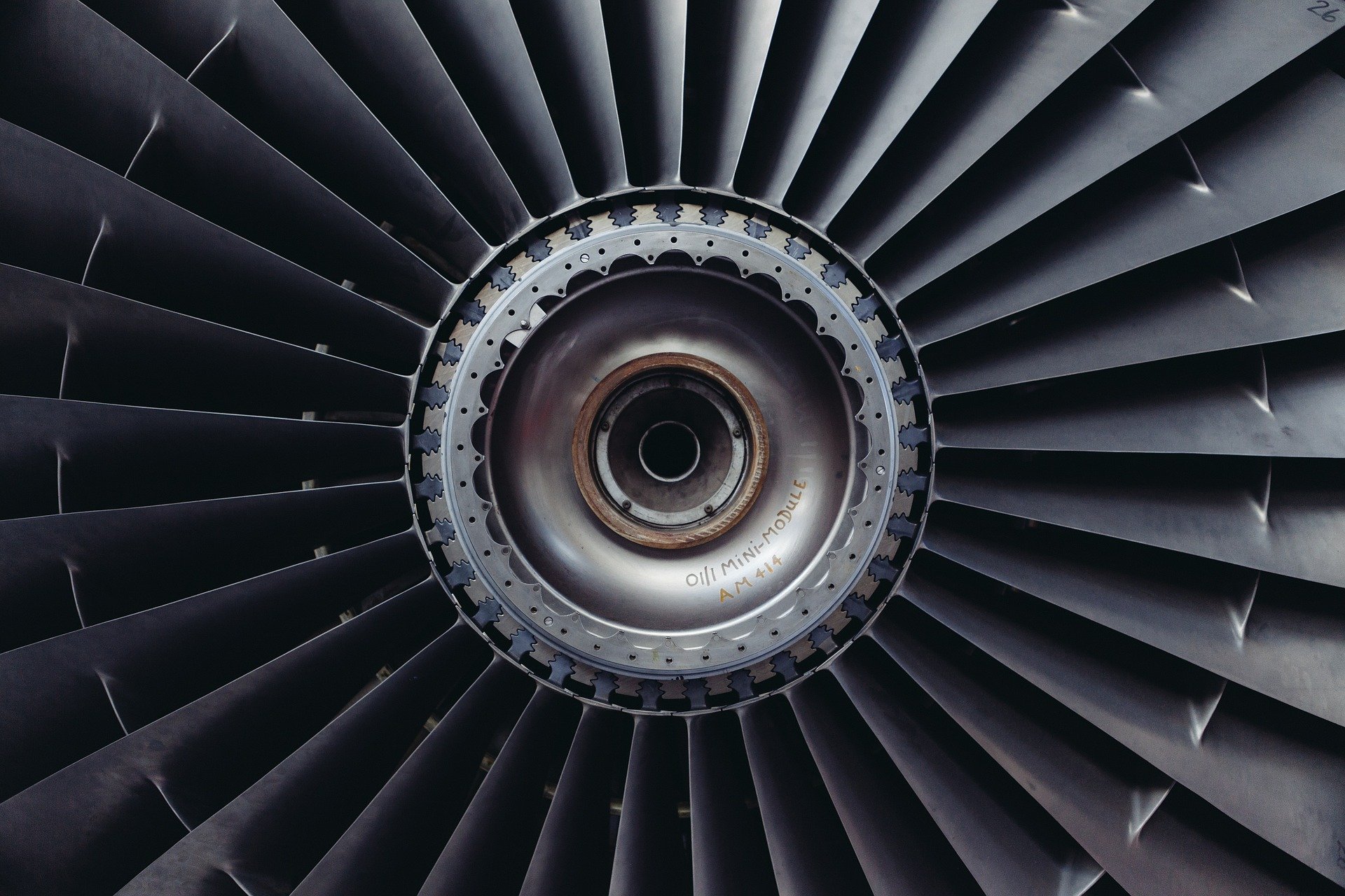 Close-up of a jet engine fan hub with radial blades and a mini-module label | H&Z