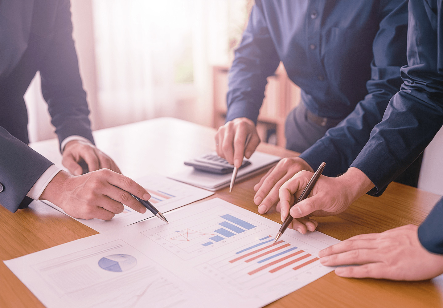 Business consultants negotiating and analyzing charts during a strategy meeting, focusing on boosting negotiations and optimizing outcomes.