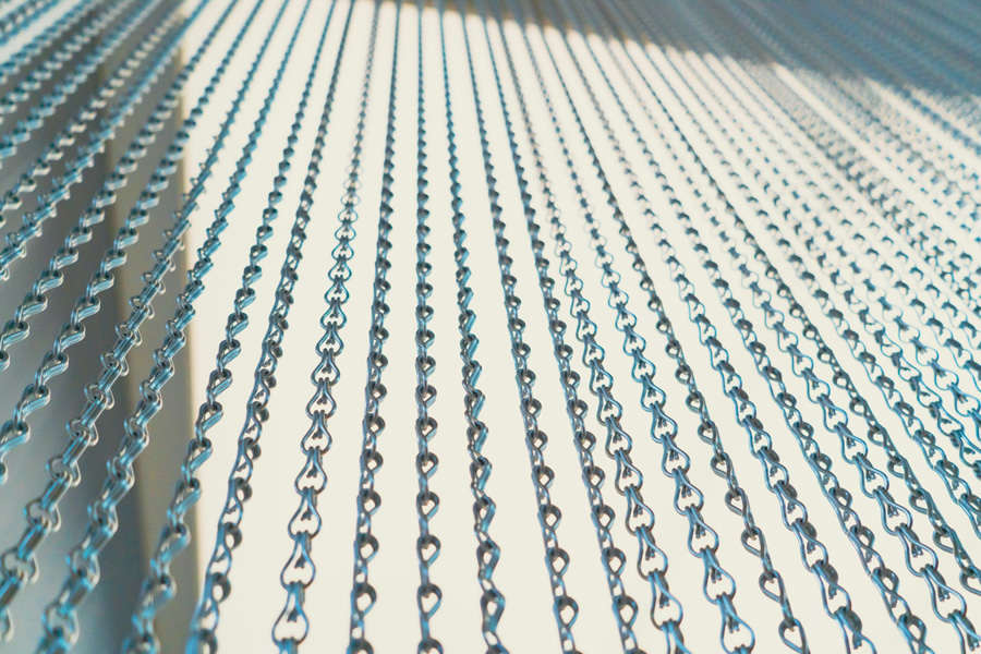 Close-up rows of metal chains hanging in parallel, symbolising interconnected supplier sourcing chains and the strength of procurement networks in consulting.
