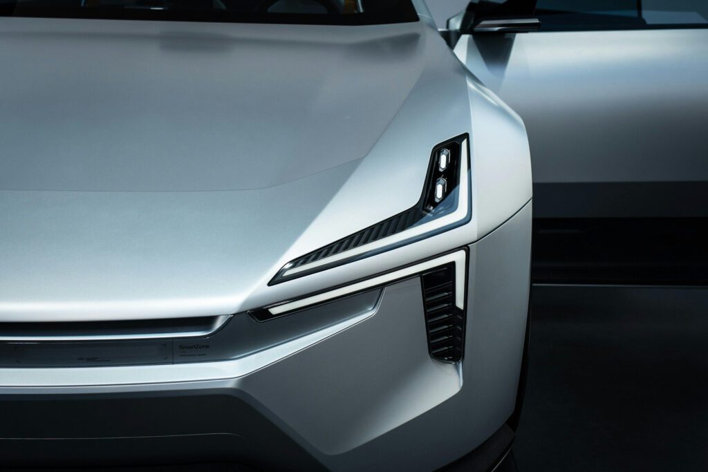 Close-up of a futuristic silver electric car's front end with sharp LED headlights and aerodynamic lines, symbolizing modern automotive innovation relevant to consulting