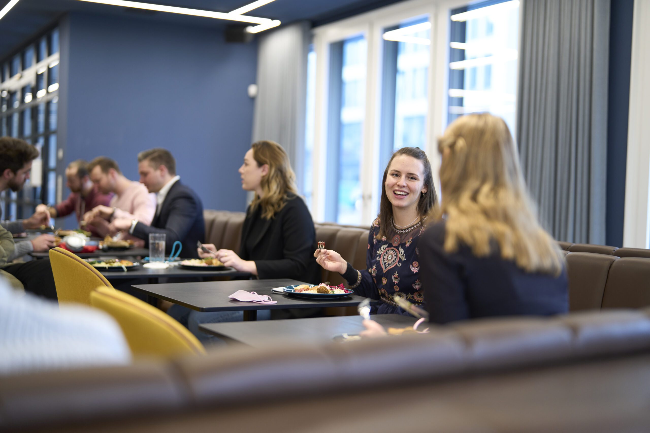 Consulting team members enjoying lunch together at a modern dining area, fostering collaboration and team spirit at H & Z.