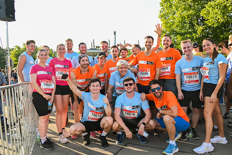 H&Z consulting team group photo at an outdoor running event wearing branded shirts, representing teamwork, corporate wellness, and community engagement.