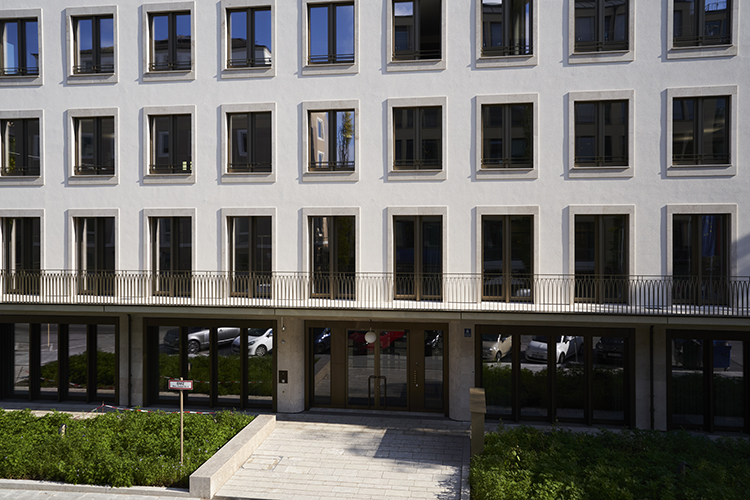 Facade of a modern office building with symmetrical windows and landscaped entrance, representing a professional corporate environment for consulting headquarters.