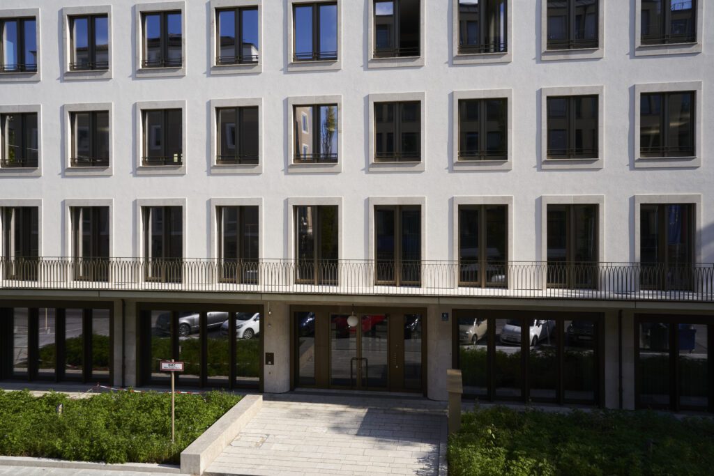 Modern office building with large windows and a stone facade, representing a professional corporate environment for consulting activities.
