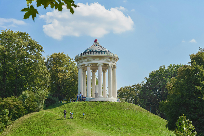Classical pavilion on a grassy hill in a lush park, representing heritage and inspiration for strategic consulting at H&Z.