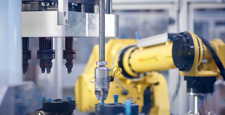 Industrial robotic arm working in a manufacturing facility, illustrating advanced automation and process efficiency achieved through consulting expertise.