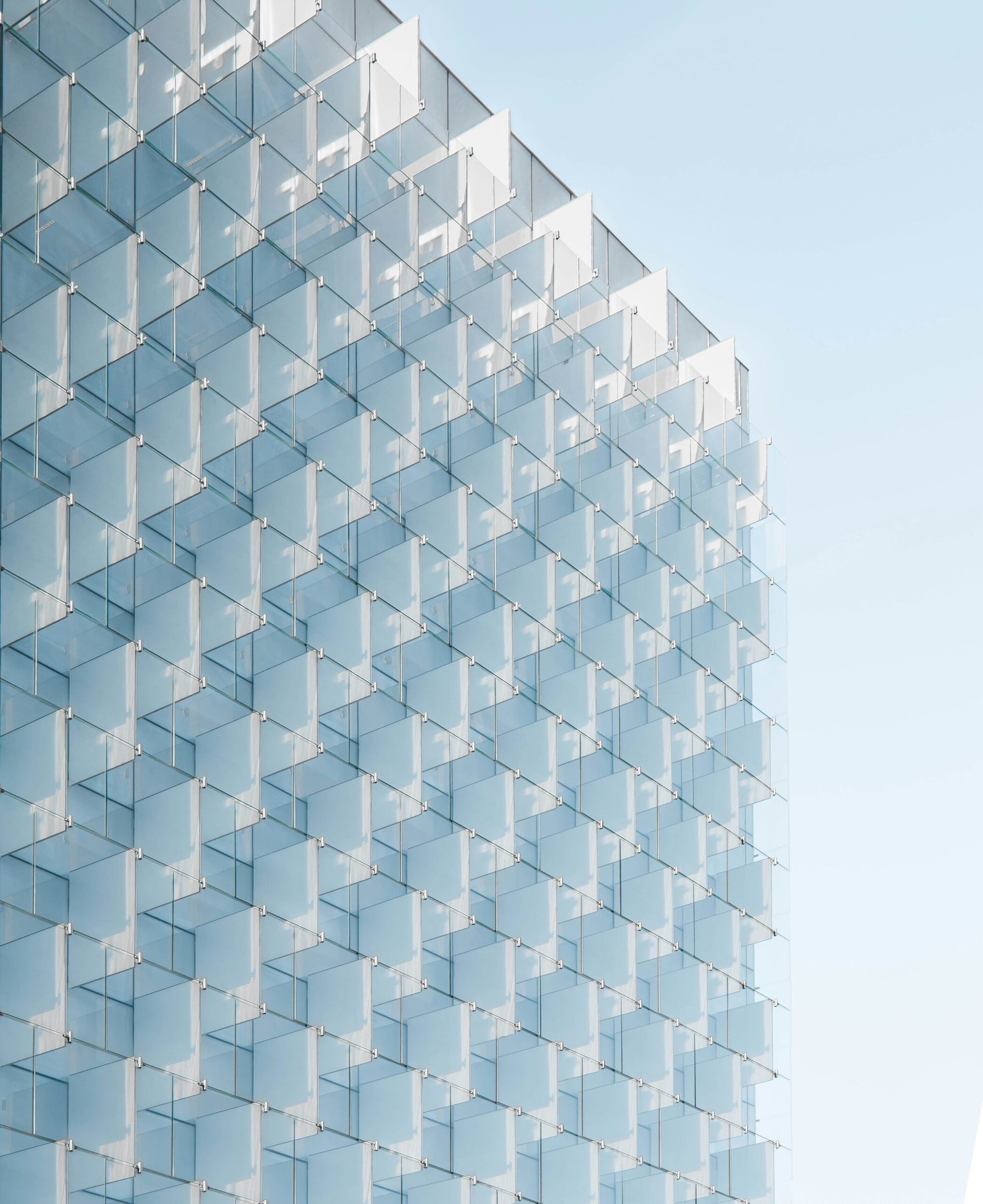 Modern glass building with a repeating cube pattern reflecting contemporary architectural design and symbolizing innovative real estate and infrastructure consulting solutions.