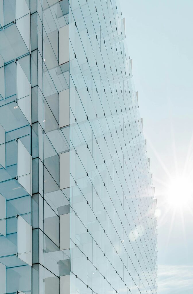 Modern glass skyscraper catching the sunlight, symbolizing transparency and growth during corporate restructuring and strategic consulting initiatives.