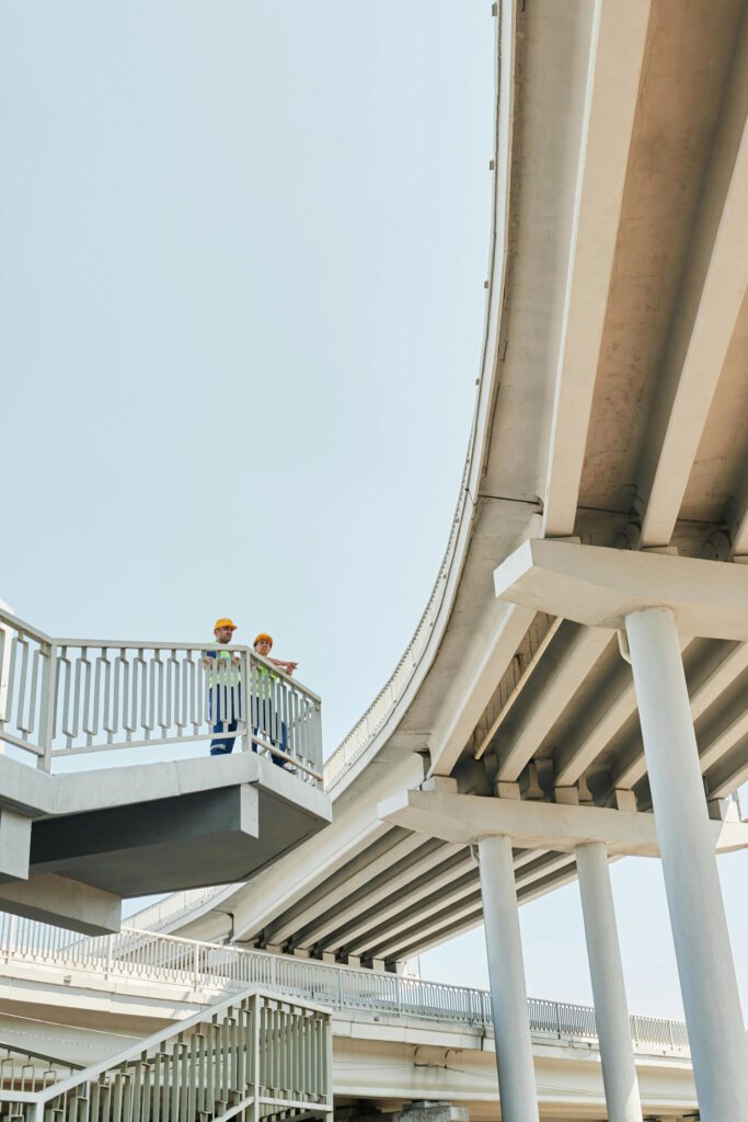 Modern elevated highway structure with a person leaning on the railing, representing urban infrastructure, engineering excellence, and the strategic oversight our consulting delivers.