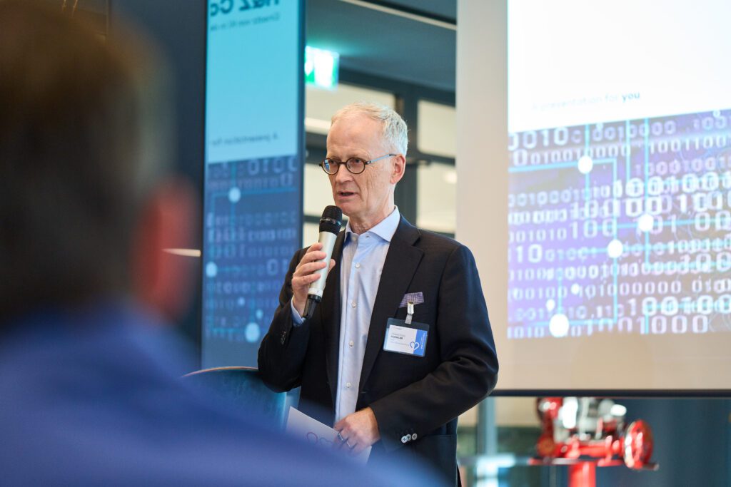 Senior speaker presenting on digital transformation with data visuals | H&Z