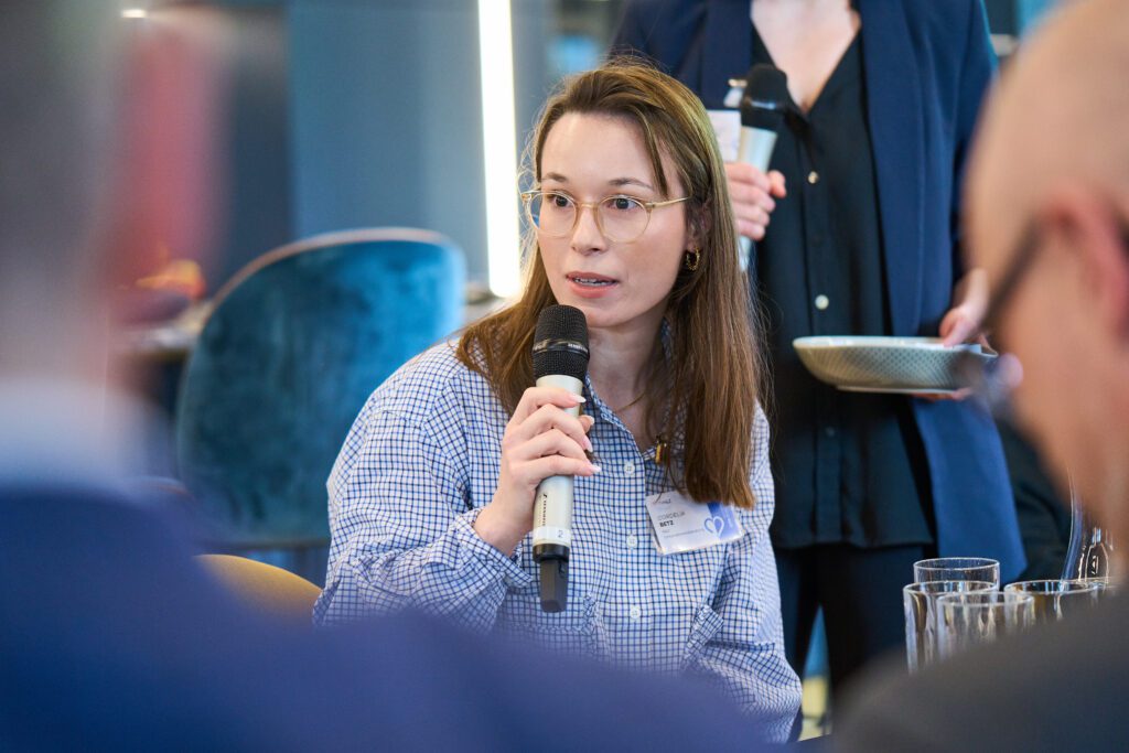 Female professional asking a question during a panel discussion | H&Z