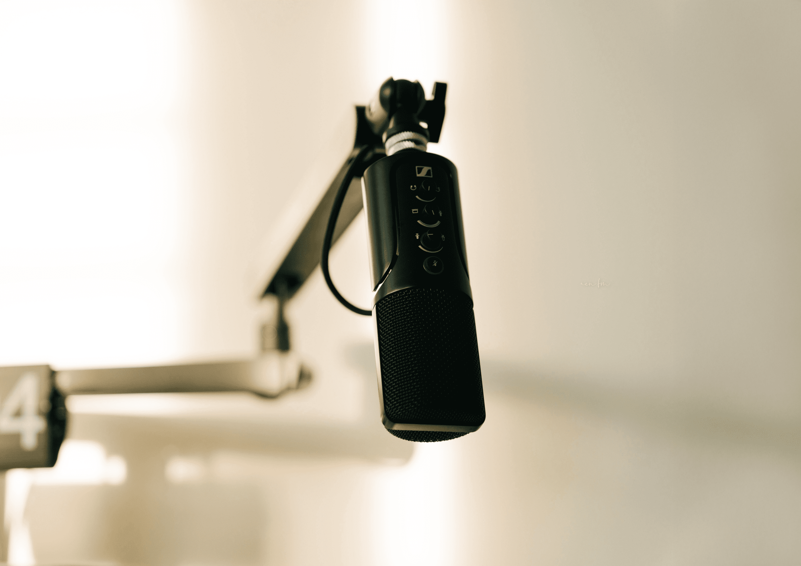 Close-up of a vintage-style studio microphone on a boom arm with a warm sepia tone, symbolizing podcasting and professional communication