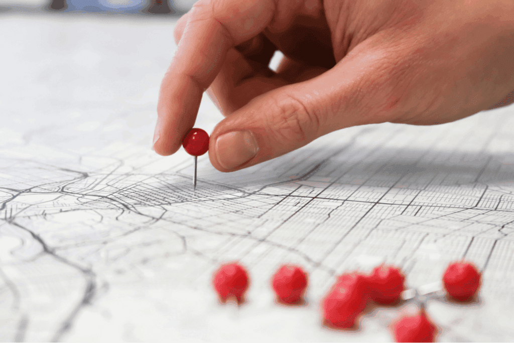 Hand placing a red pin on a technical drawing to mark a project milestone | H&Z
