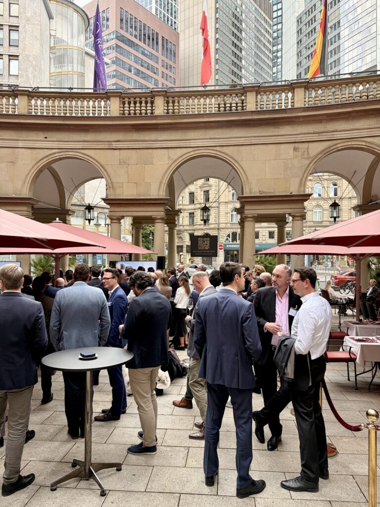 Guests networking under red umbrellas in the courtyard of the Frankfurter Hof hotel | H&Z