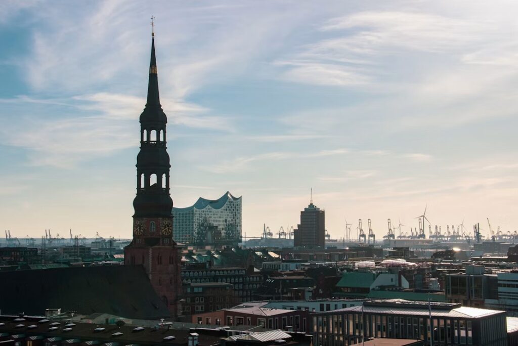 Hamburg skyline with St. Katharinen church spire, Elbphilharmonie and harbour cranes in the background | H&Z